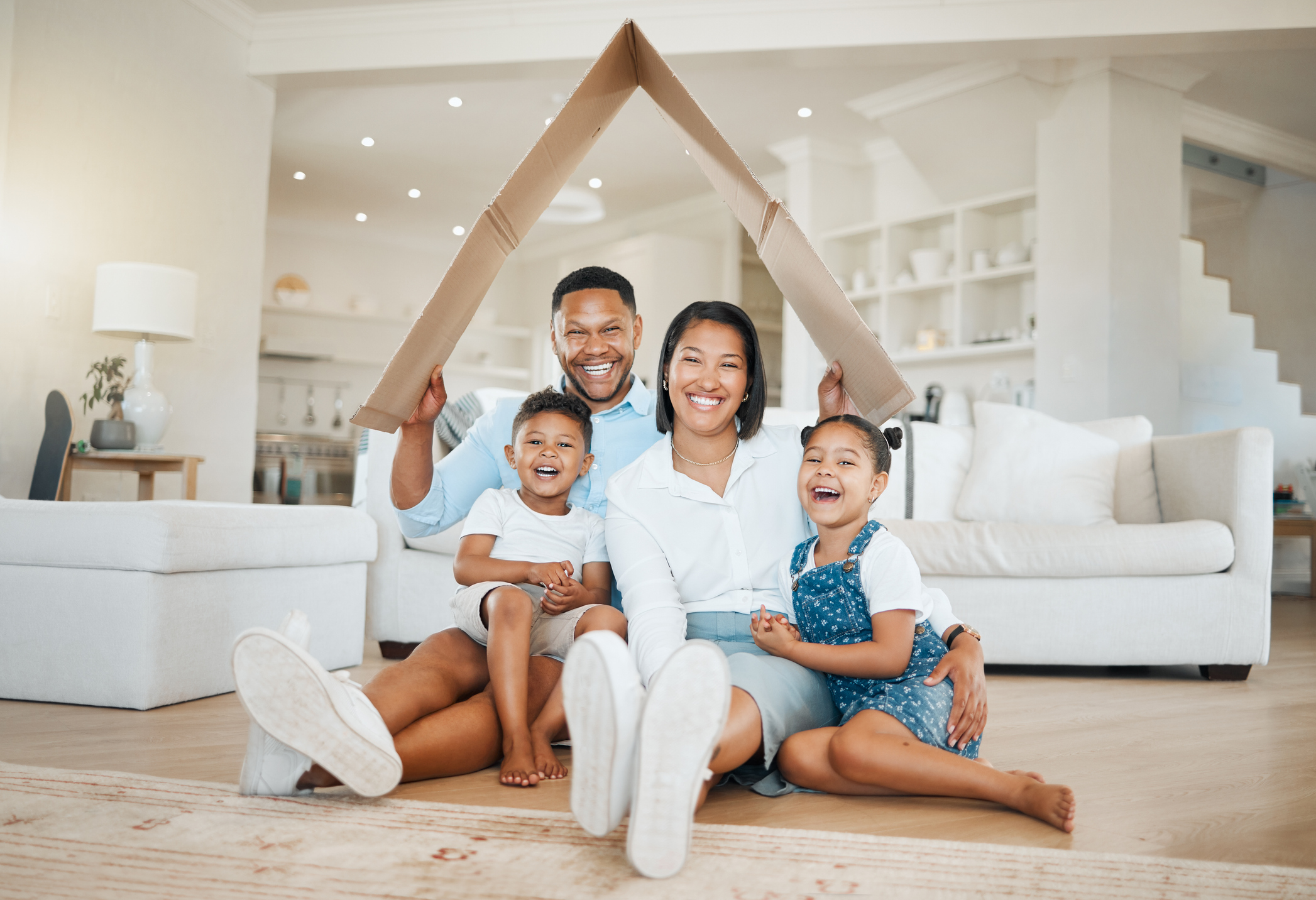 A happy family sitting in their new home, symbolizing financial security and affordable mortgage options through FHA loans.