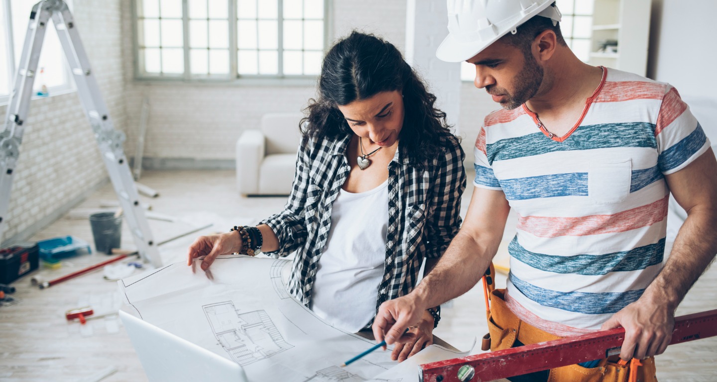 A couple discussing home renovation plans, using a Fix & Flip loan to finance their investment.