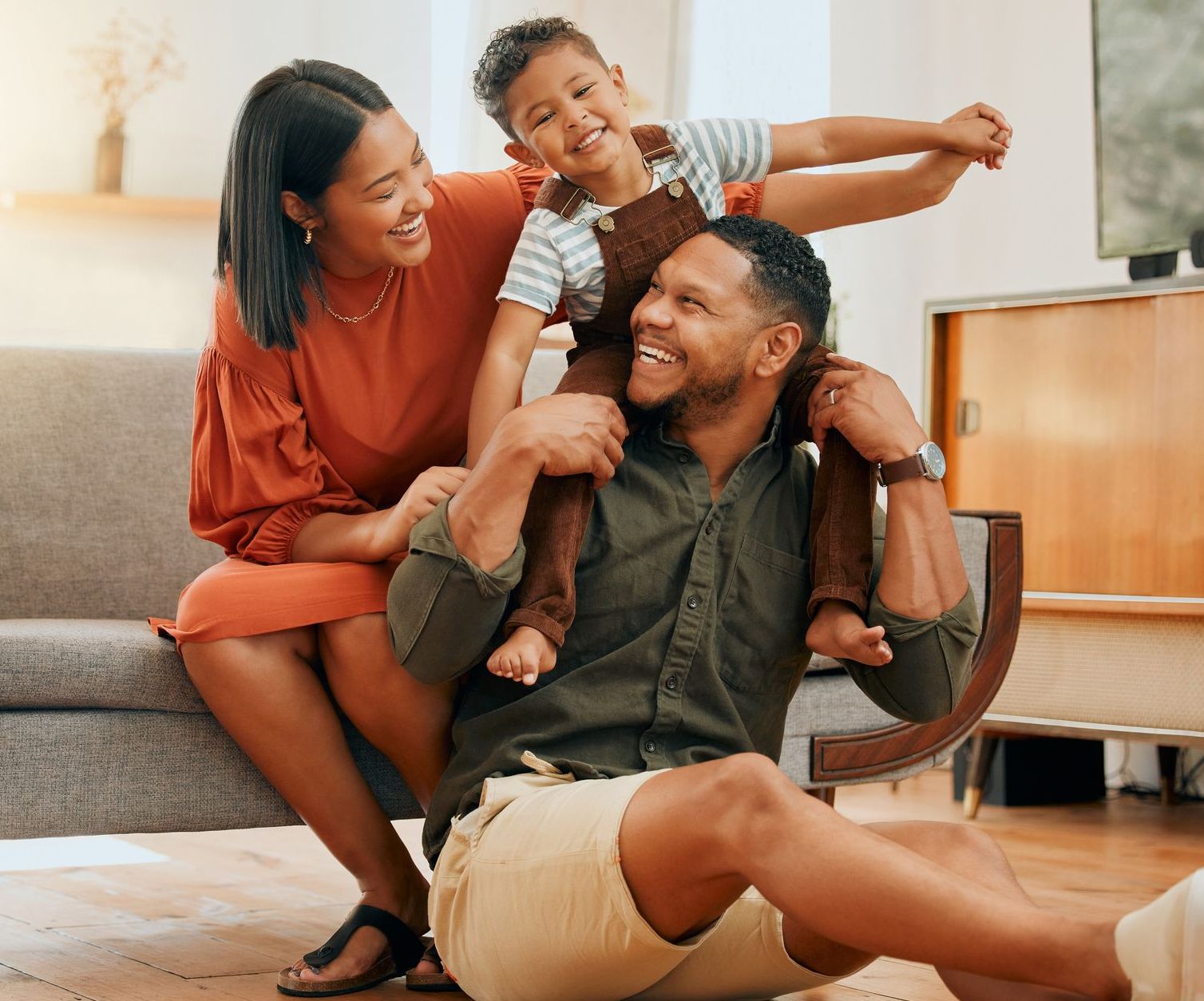 Smiling parents with their young child at home, showcasing the benefits of flexible home financing.