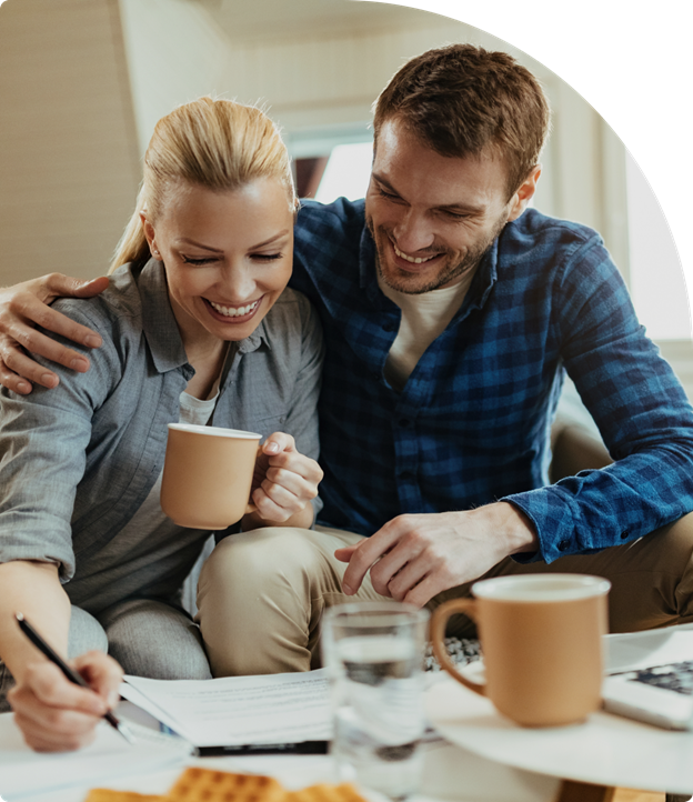 A couple smiling while reviewing mortgage paperwork, symbolizing a stress-free loan approval process.