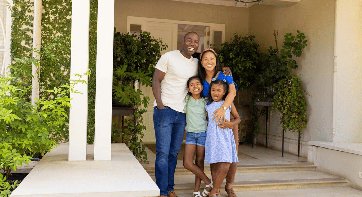 Happy family standing outside their home, representing homeowners exploring HELOC options for debt consolidation.