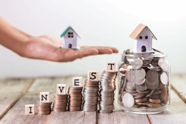 Mini houses on stacks of coins representing real estate investing and HELOC options for second homes or investment properties in South Carolina.