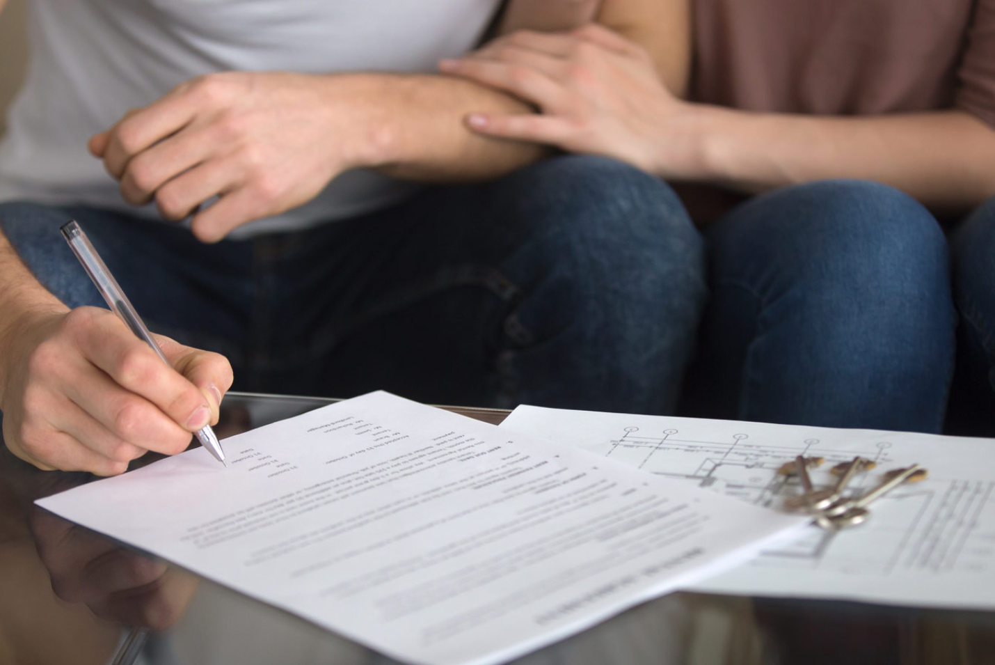 Homeowners reviewing and signing home equity loan paperwork at a table